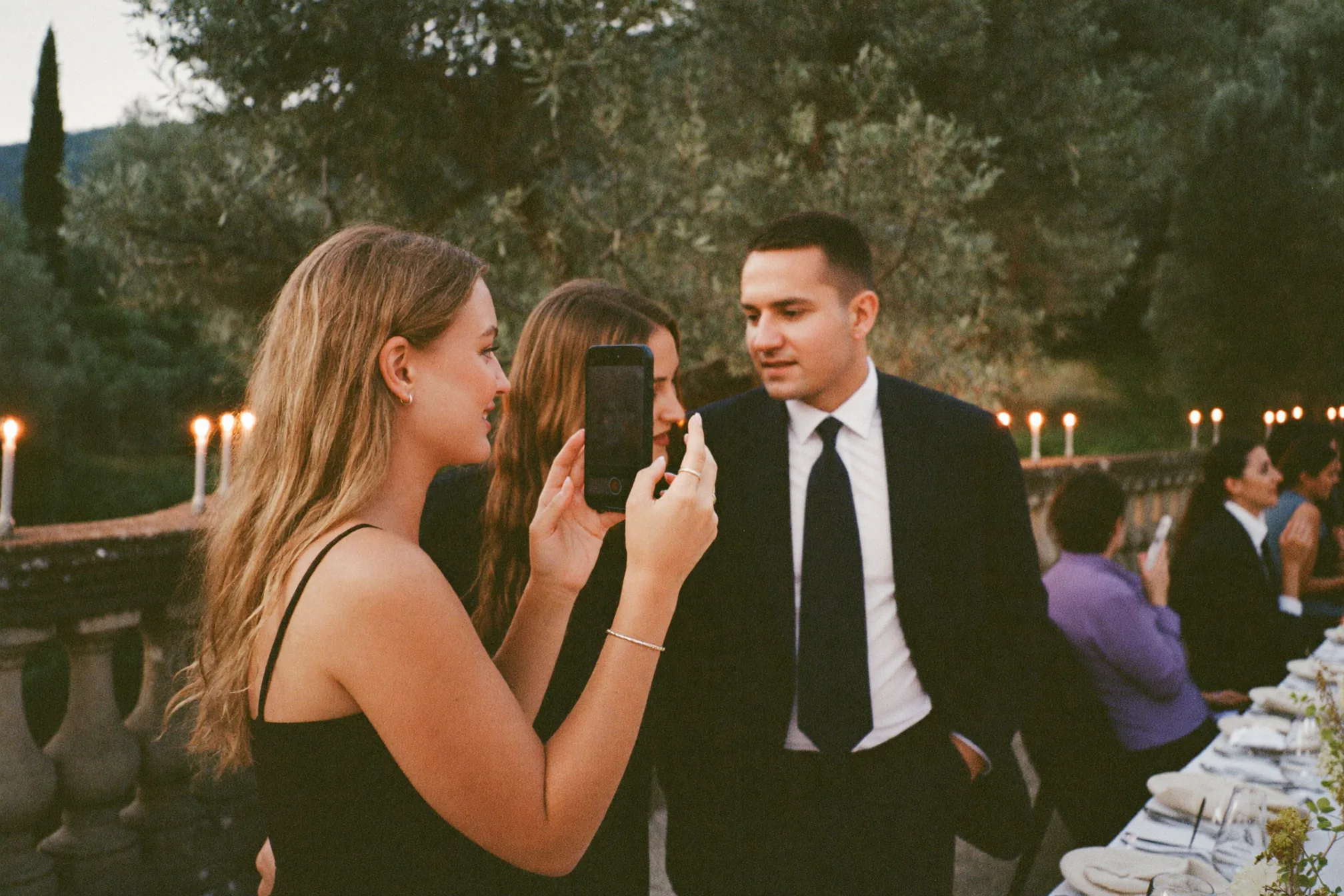 Un'invitata registra un videomessaggio accanto a un cartello con codice QR su un tavolo da matrimonio illuminato con luce soffusa